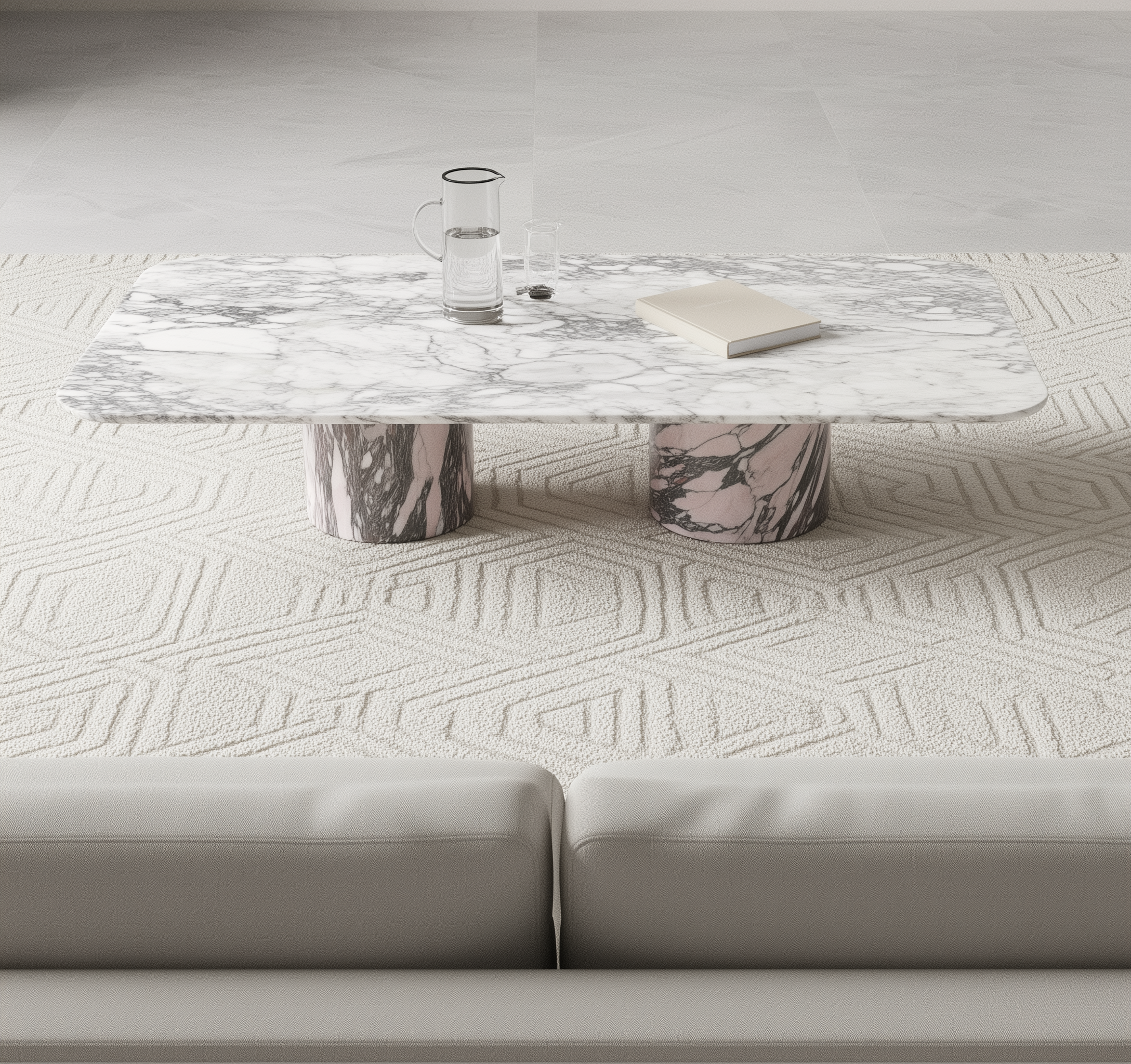 Arabescato rectangular marble coffee table with a glass and book on a textured white floor.
