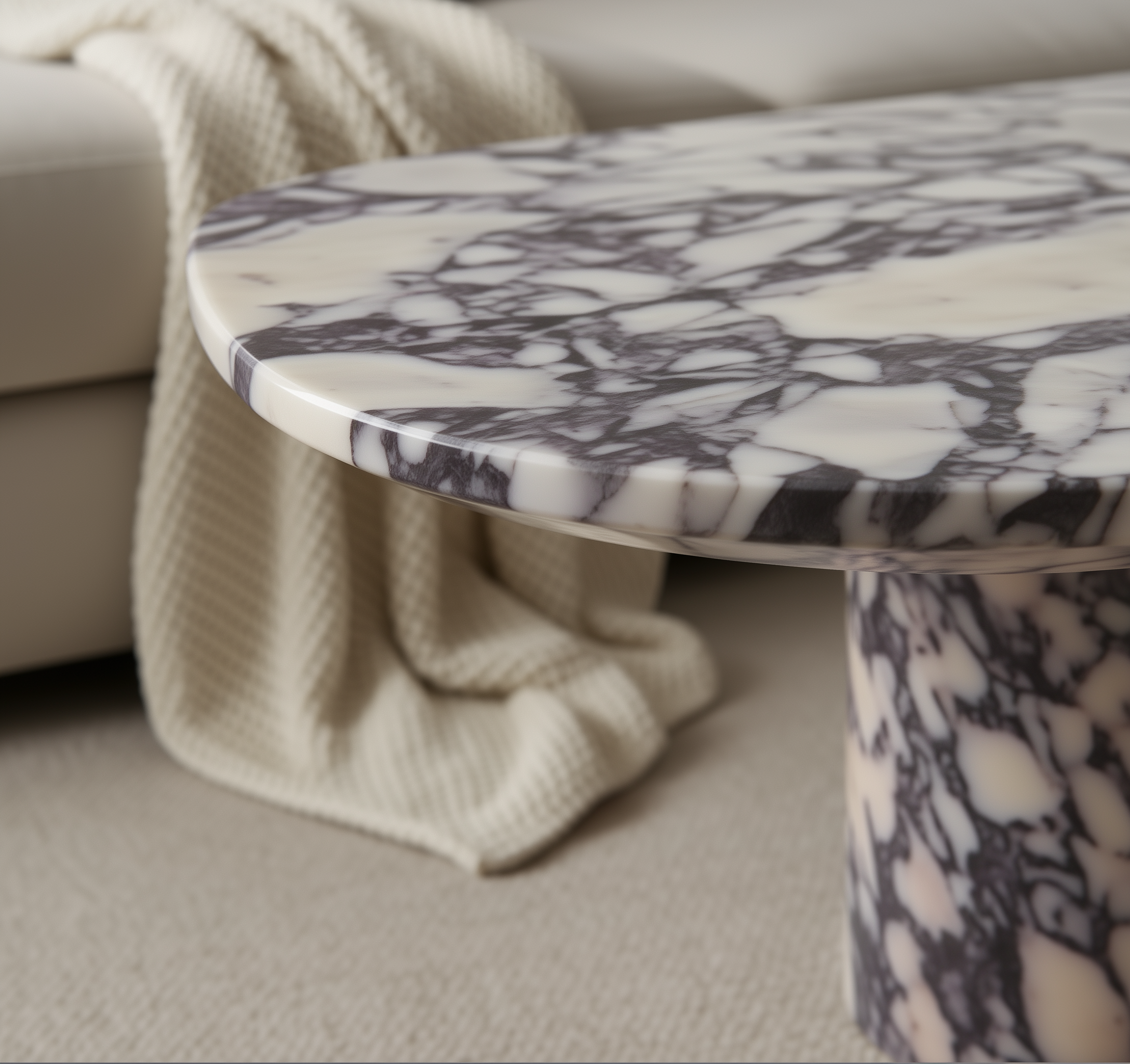 Marble-patterned side table in a living room setting with a beige sofa and blanket.