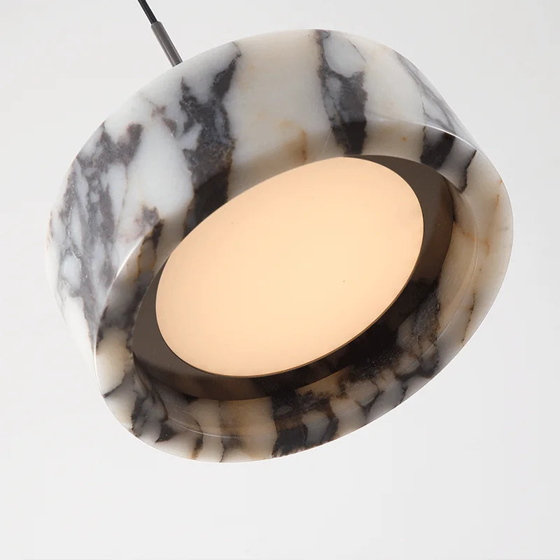 Marble-patterned pendant light with a white bulb on a white background