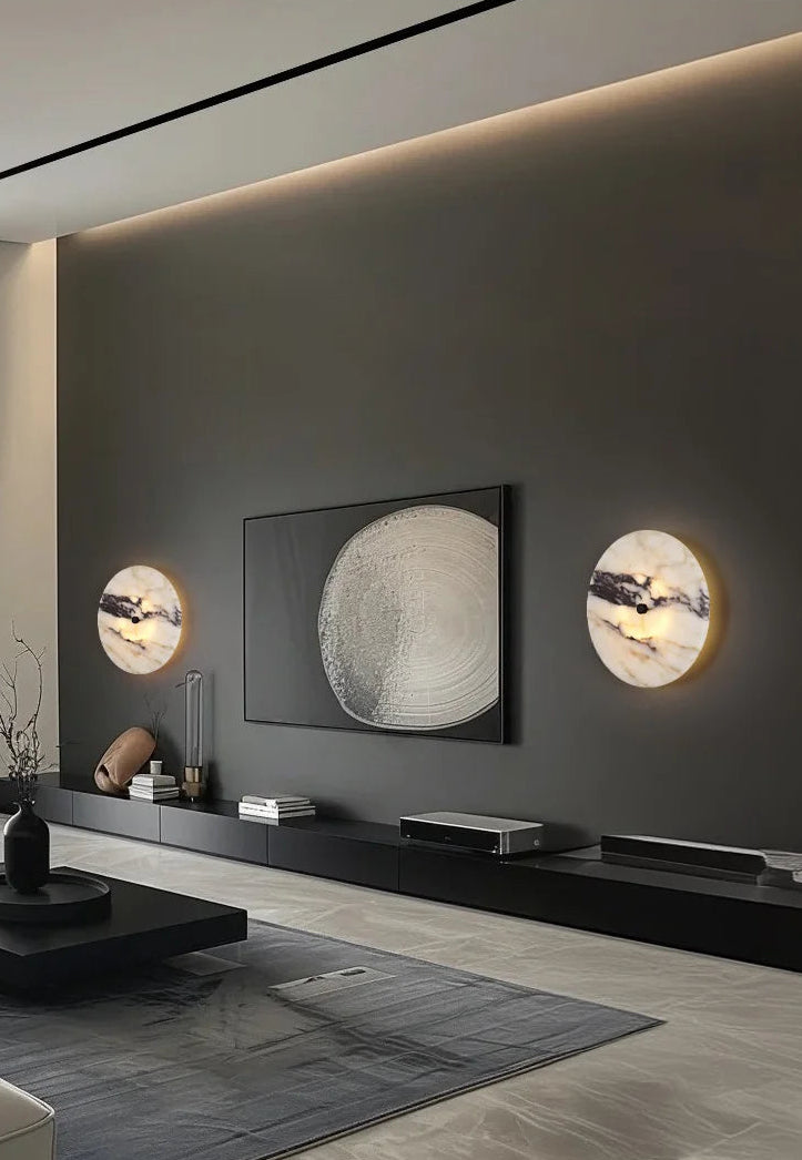 Modern living room with a television and decorative wall lights.