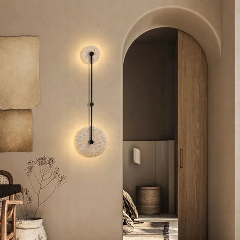 Modern wall lamp with a round design on a neutral wall.