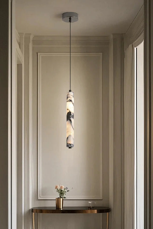 Modern pendant light hanging in a room with a mirror and small table.
