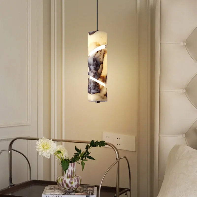 Decorative wall light fixture above a table with a vase of flowers in a bedroom setting.