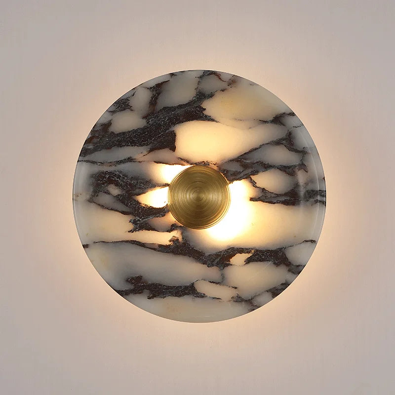 Round marble-patterned wall light fixture with a gold interior on a neutral background