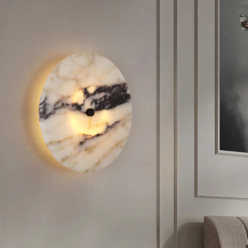 Marble-patterned wall sconce on a neutral wall with a framed picture.