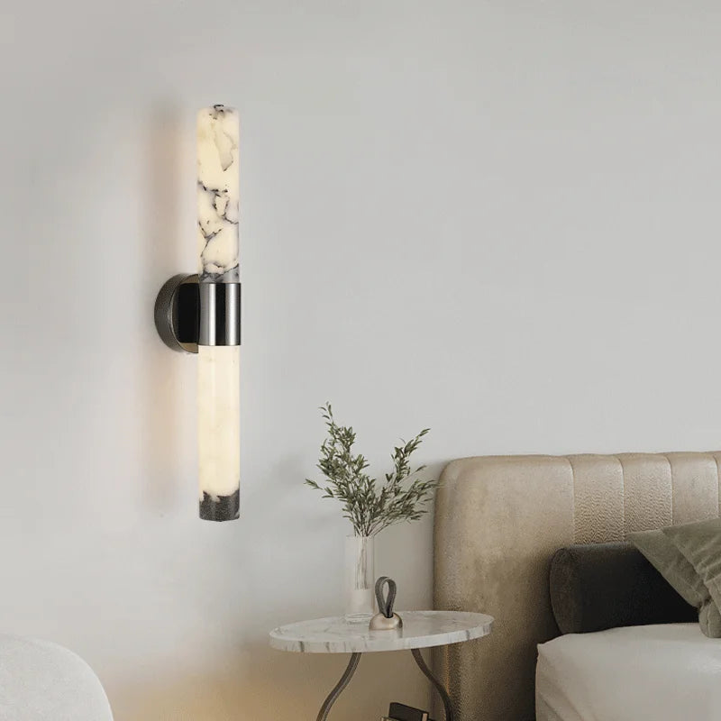 Modern wall sconce in a living room setting with a sofa and small table.
