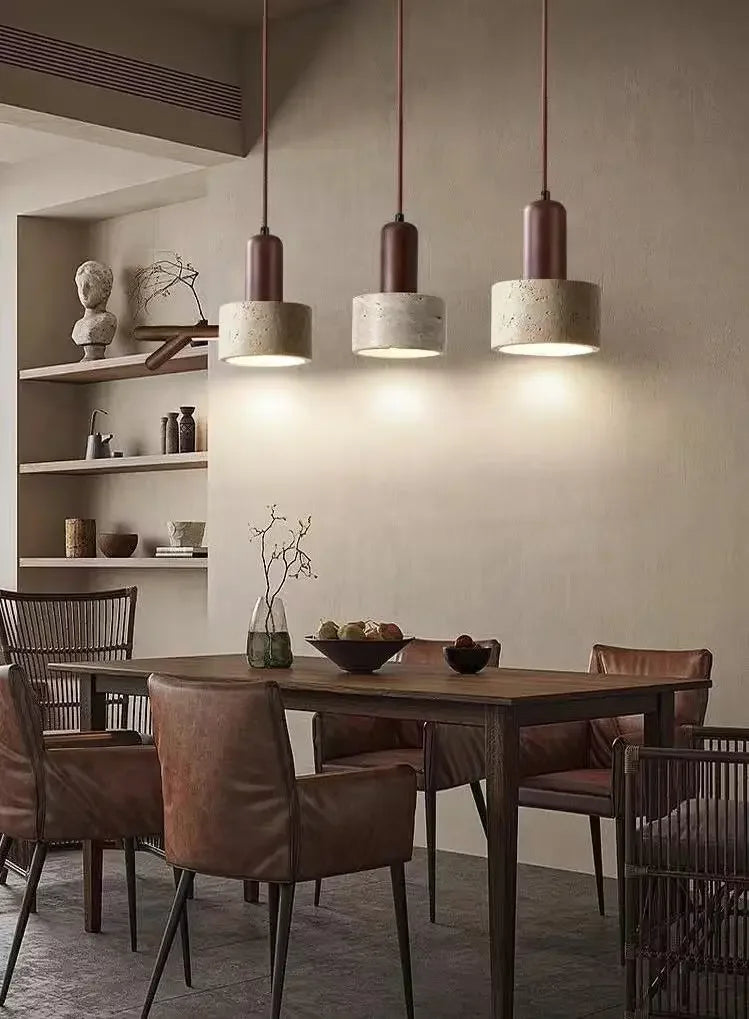 Dining room with wooden table and chairs, pendant lights, and shelves.