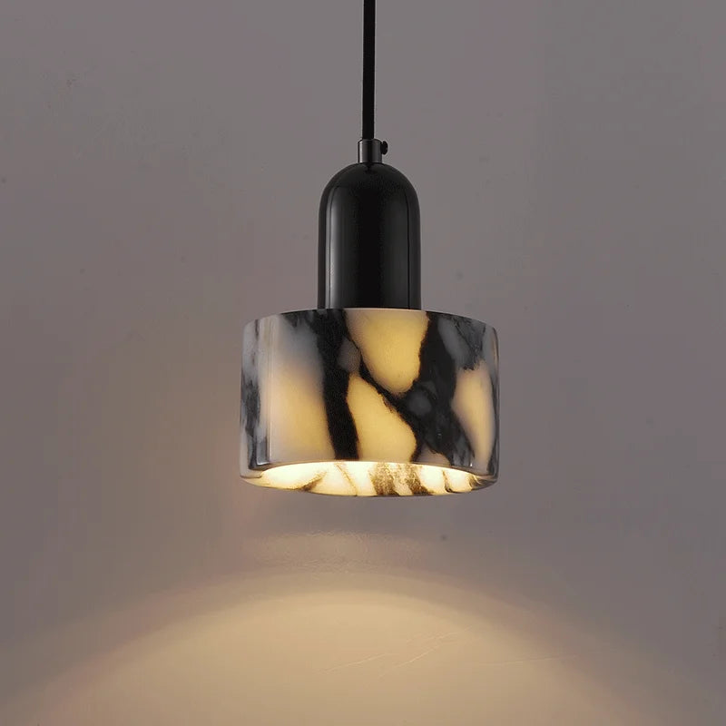 Marble-patterned pendant light with black fixture on a gray background