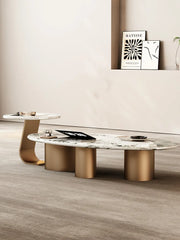 Modern coffee table with marble top and gold legs in a room setting.