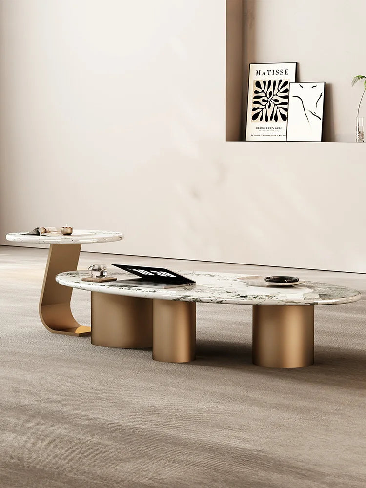 Modern coffee table with marble top and gold legs in a room setting.