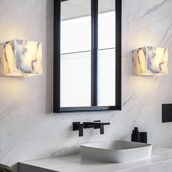 Modern bathroom with a mirror, sink, and wall lights.
