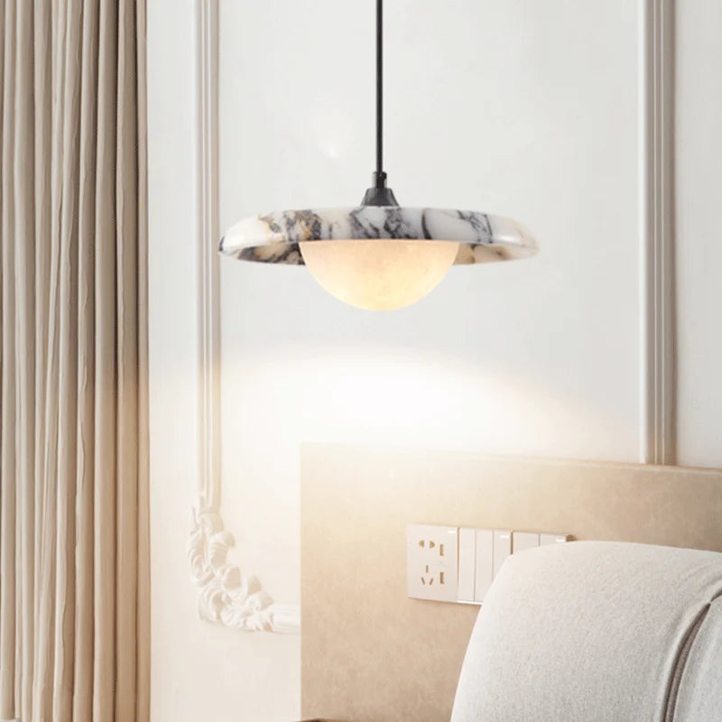 Marble-patterned pendant light hanging above a bed in a bedroom setting.