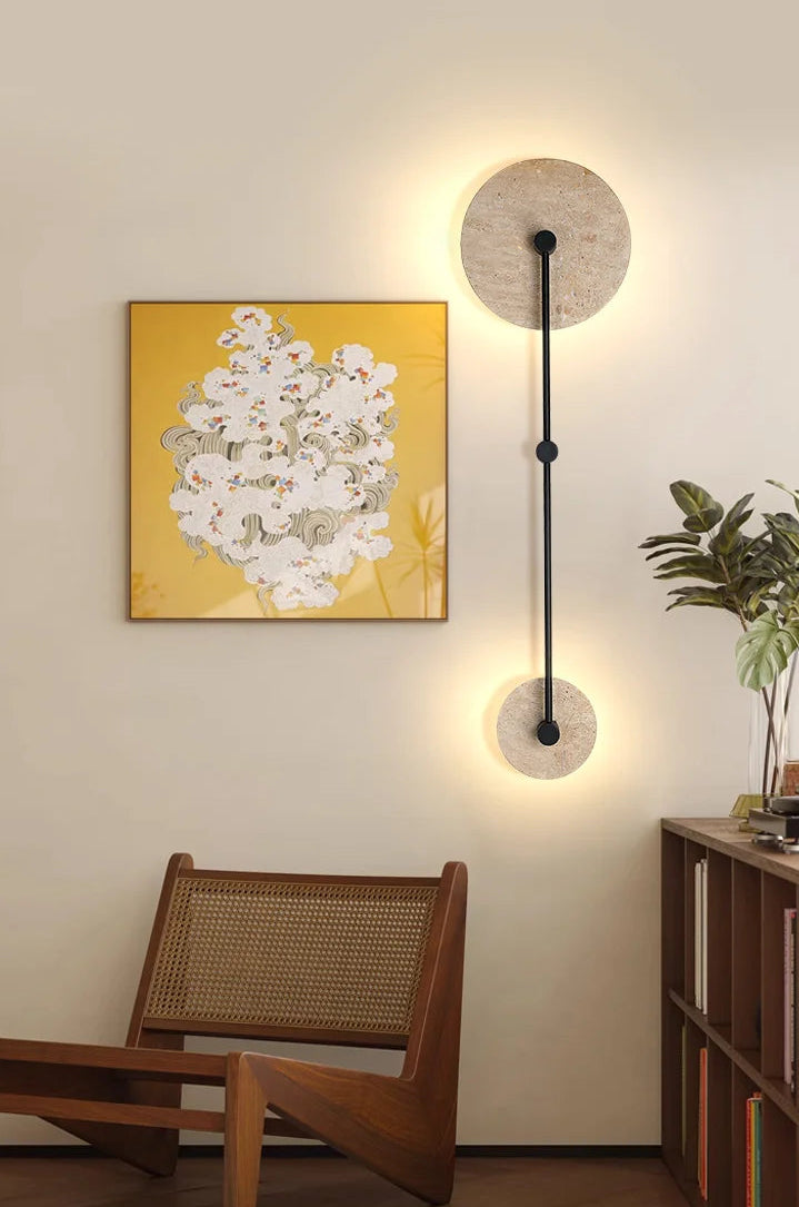 Modern wall light fixture with a decorative painting and chair in a room setting.