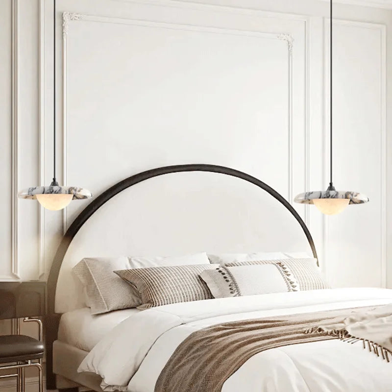 Modern bedroom with a round bed and decorative pillows.