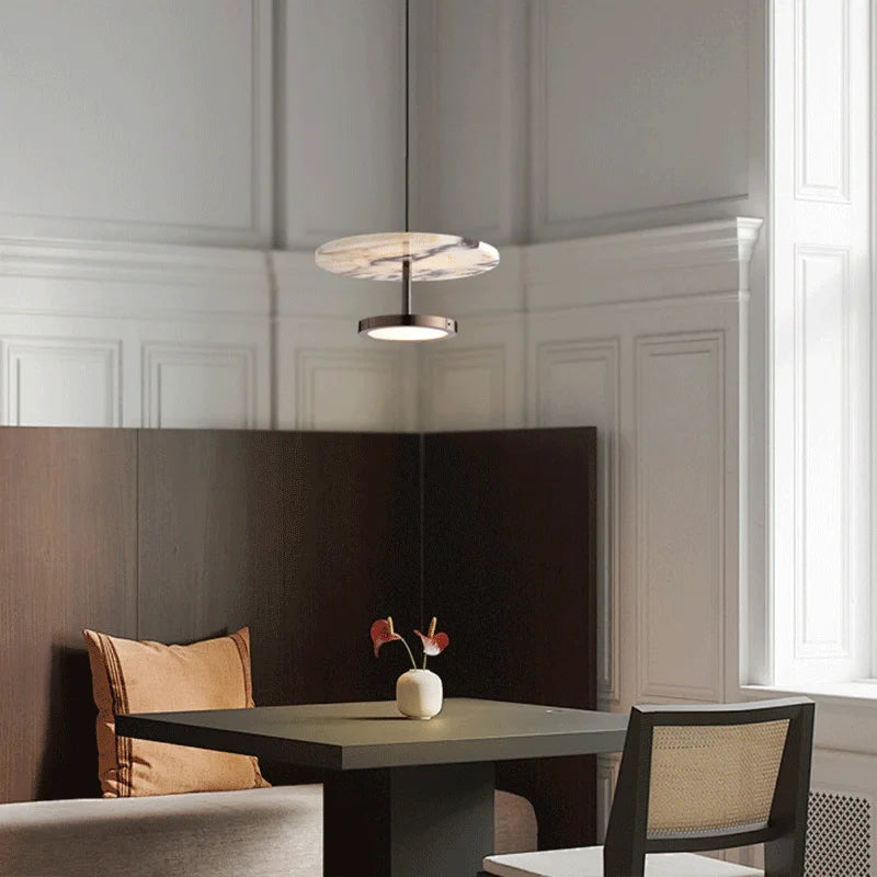Modern interior with a table, chairs, and a pendant light fixture.