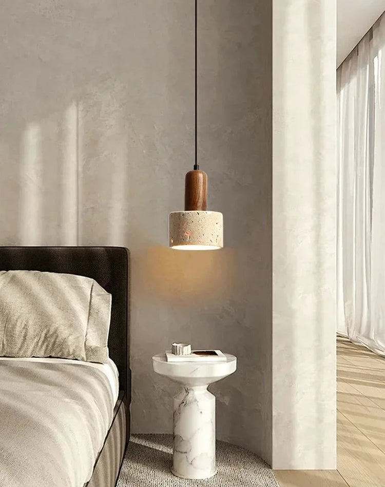 Modern bedroom with a pendant light, marble side table, and bed.