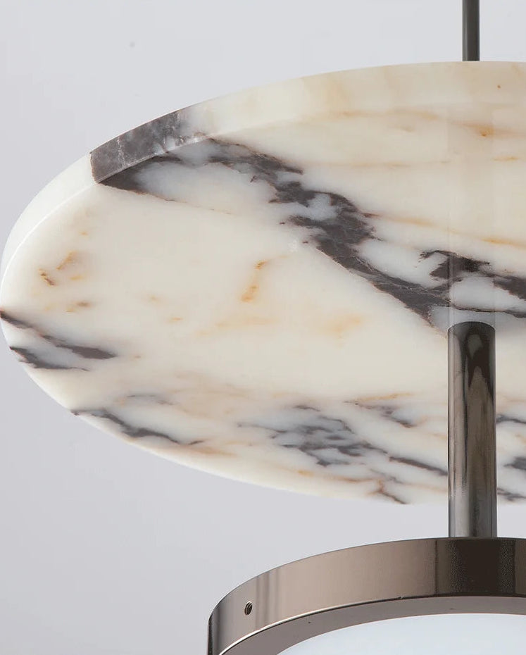 Close-up of a marble-patterned light fixture with metallic base on a gray background