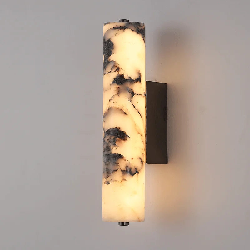 Wall-mounted cylindrical light fixture with marble-like pattern on a gray wall.