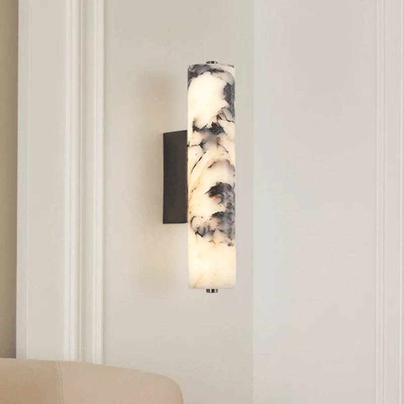 Wall-mounted light fixture with marble-like design on a neutral wall.