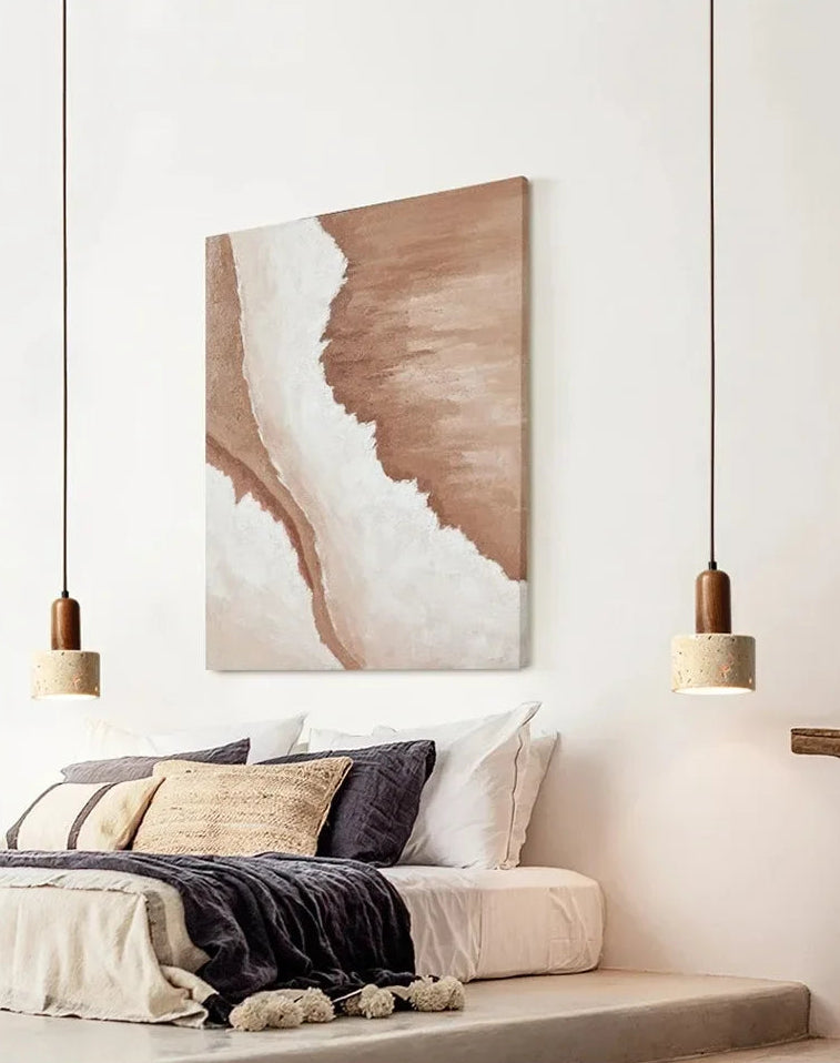 Abstract wall art above a bed in a bedroom with pendant lights.