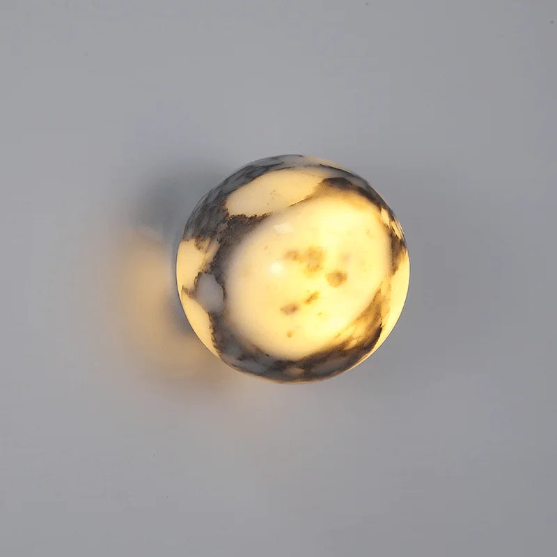 Round marble-like object with a warm glow on a gray background