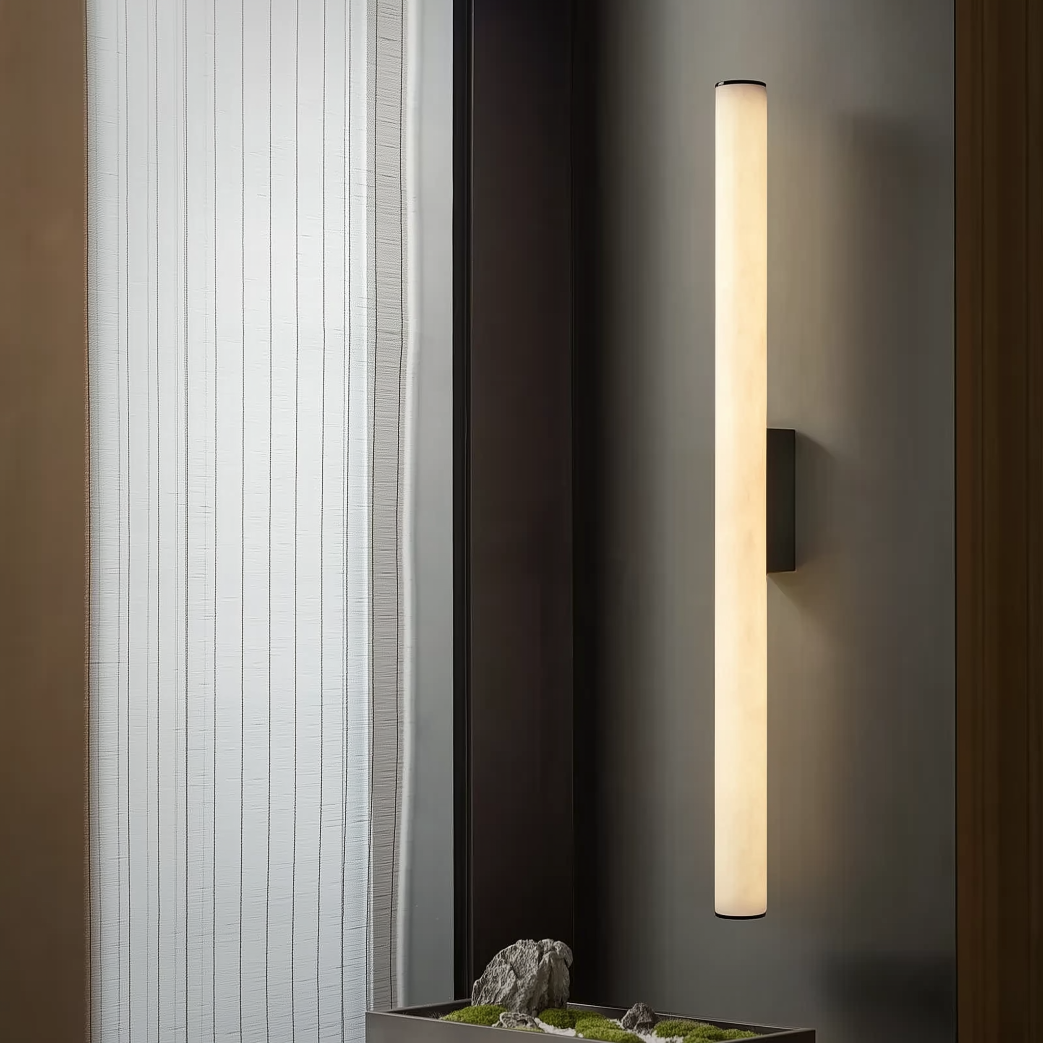 Modern wall-mounted light fixture on a dark wall with a minimalistic design.