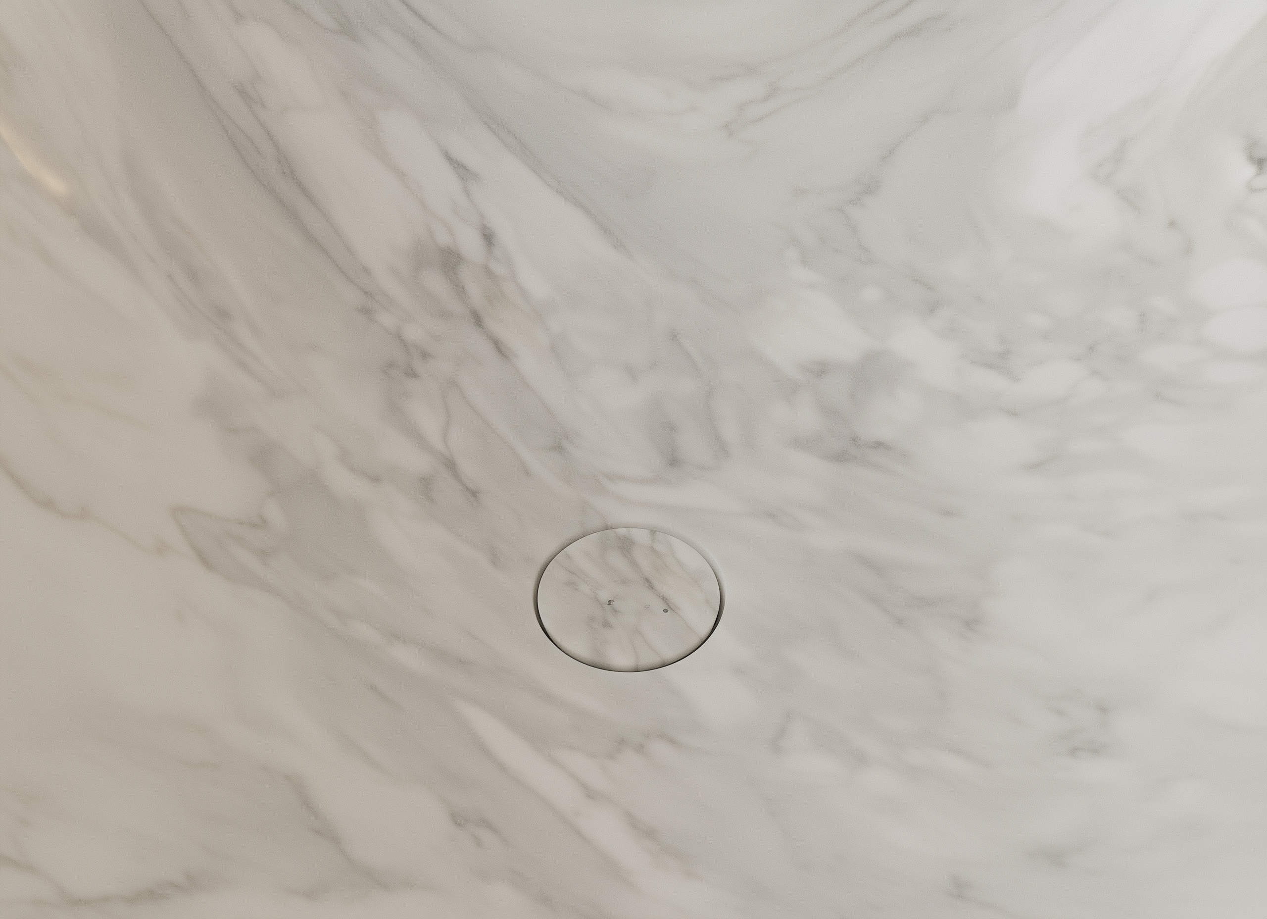 Close-up of a Palissandro marble-patterned floor with a circular drain.